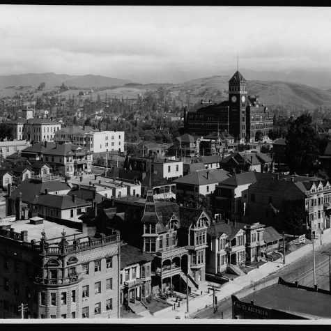 Black and white photo of Los Angeles in 1904, capturing several large homes and buildings, with rolling foothills in the distant background.