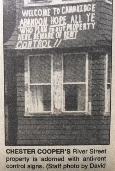 A sign on a building reads "Welcome to Cambridge. Abandon hope all ye who plan to buy property here. Beware of Rent Control!!"